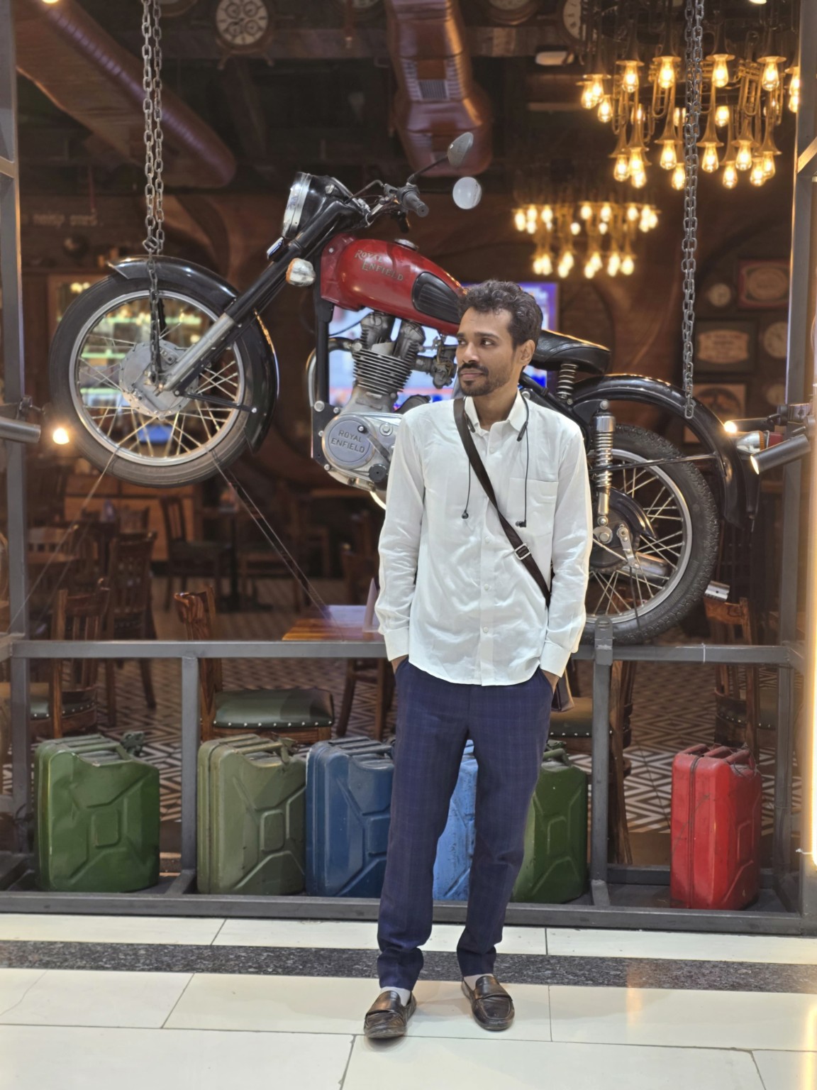 Emran Russell, founder of CarGadgetHQ, standing in front of a vintage Royal Enfield motorcycle